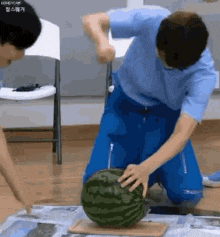 a man is cutting a watermelon with a knife .