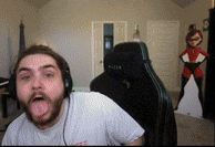 a man wearing headphones is sticking his tongue out while sitting in a gaming chair