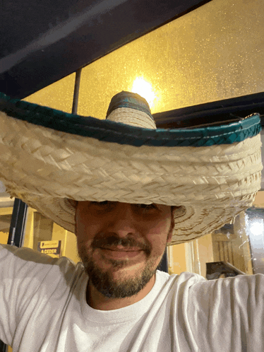 a man wearing a sombrero stands in front of a yellow sign that says locker