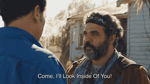 a man with a beard is talking to another man and says " come i 'll look inside of you "