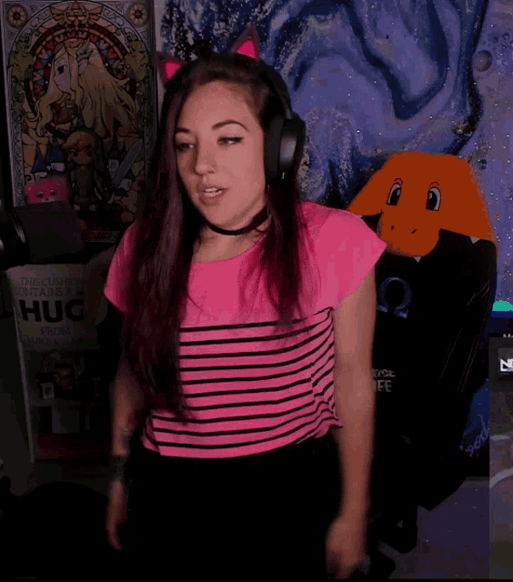 a woman wearing headphones stands in front of a poster that says " hug "