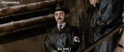 a man in a leather jacket with a swastika on his arm says au trot