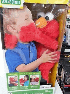 a child is holding a sesame street elmo stuffed animal .