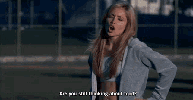 a woman says " are you still thinking about food " while standing on a field