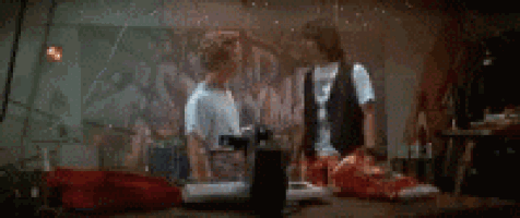 two men are standing next to each other in front of a painting in a room .
