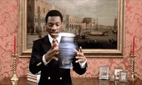 a man in a suit and tie is holding a vase
