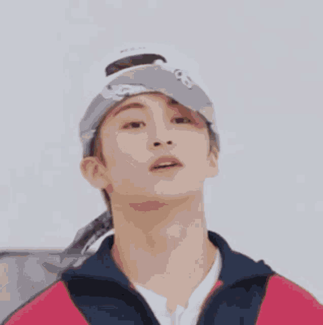 a young man wearing a bandana and a hat is looking up at the sky .