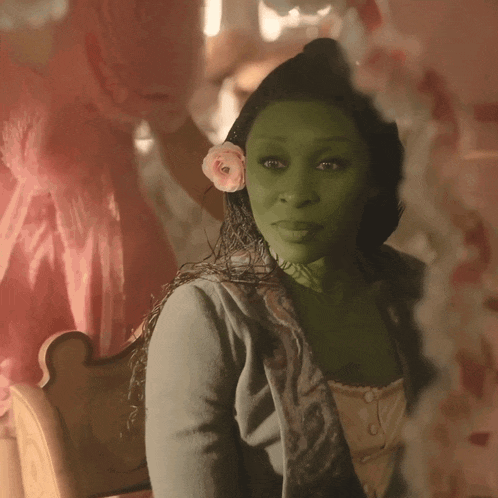 a woman with a flower in her hair is looking at herself in a mirror
