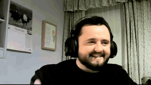 a man wearing headphones is smiling in front of a wall calendar that says november