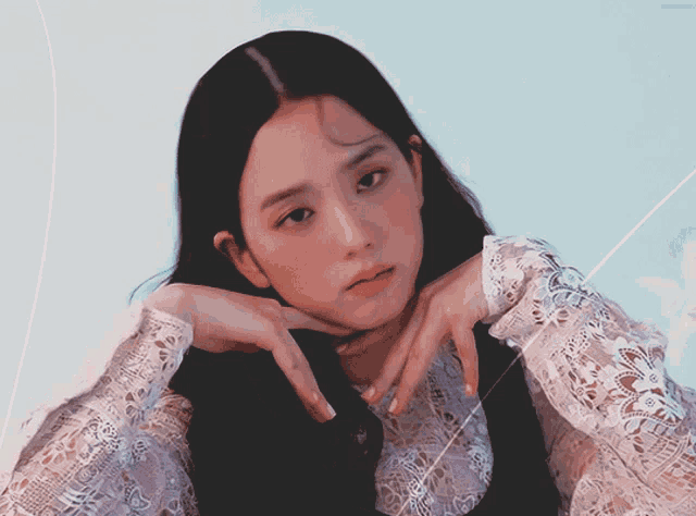 a woman with long black hair is wearing a white lace dress