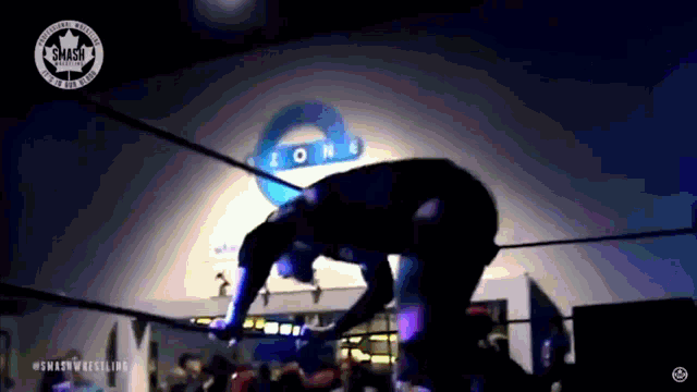 a man is wrestling in front of a smash zone sign