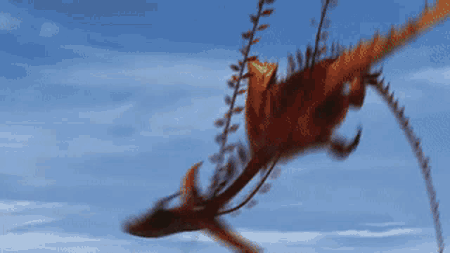 a dragon is flying through a blue sky with smoke coming out of its tail