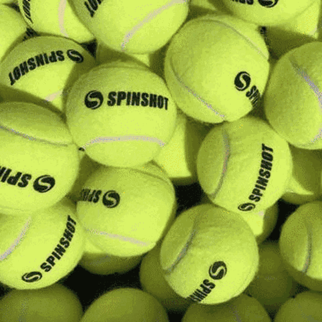 a pile of spinshot tennis balls are stacked on top of each other