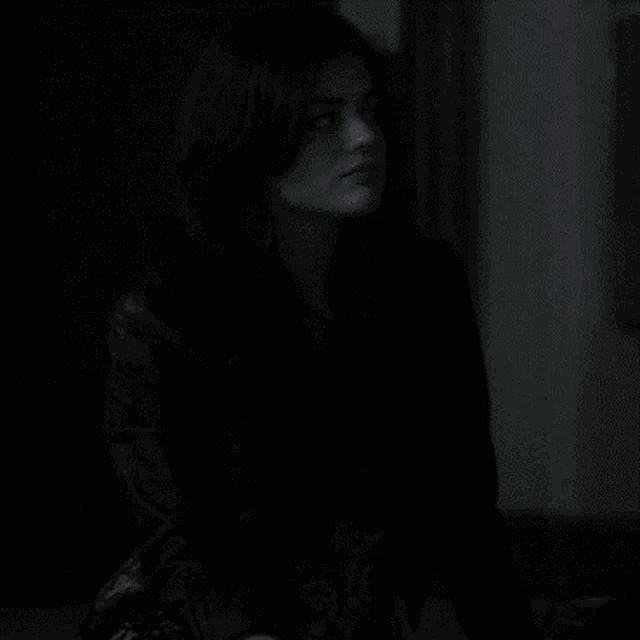 a woman in a black jacket is looking up at something