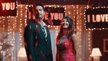 a man and a woman are standing in front of signs that say i love you