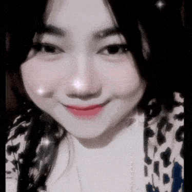 a close up of a woman 's face with a leopard print shirt and necklace .