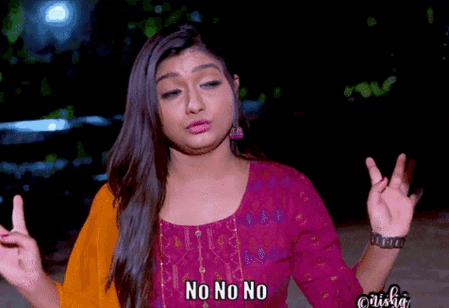 a woman in a purple top says " no no no " with her fingers crossed