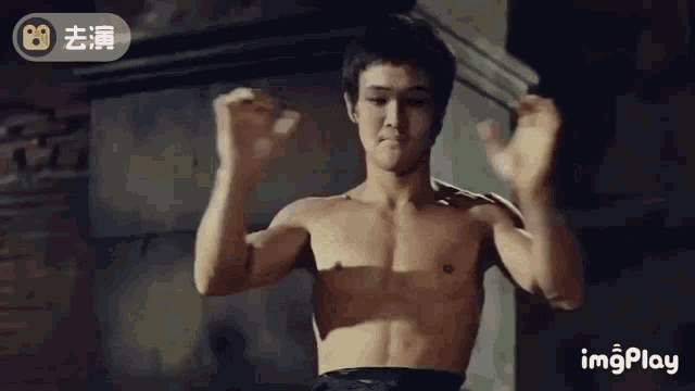 a man without a shirt is flexing his muscles in a room .