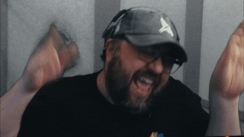 a man with a beard wearing a hat with a white x on it