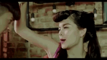 a woman is dancing with a man in a room .