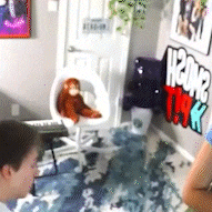a stuffed monkey is sitting in a chair in a room with a sign that says h2ona thek
