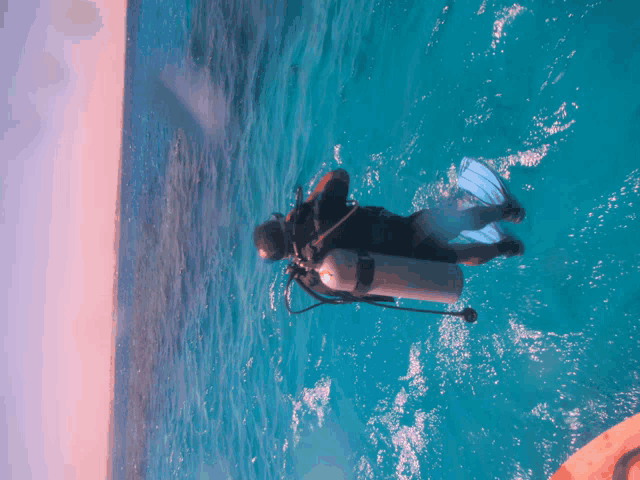 a scuba diver is swimming in the ocean while wearing flippers and a scuba tank