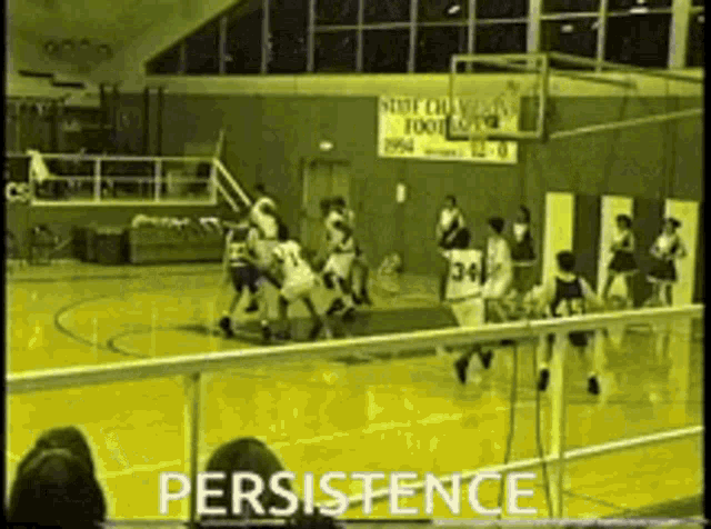 a basketball game is being played in front of a sign that says state champions football