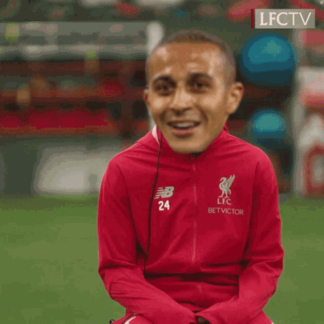 a man wearing a red jacket that says lfc bet victor