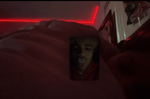 a man with a pacifier in his mouth is laying in bed