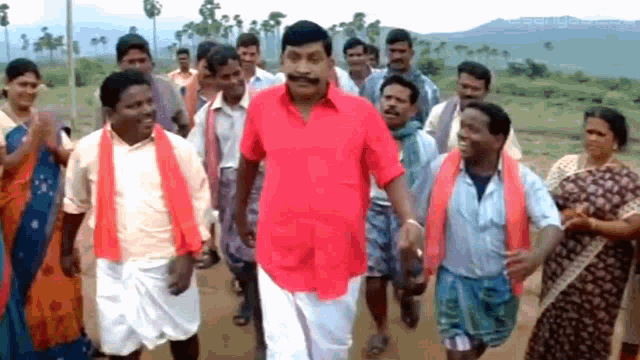 a man in a red shirt with a mustache is surrounded by other people