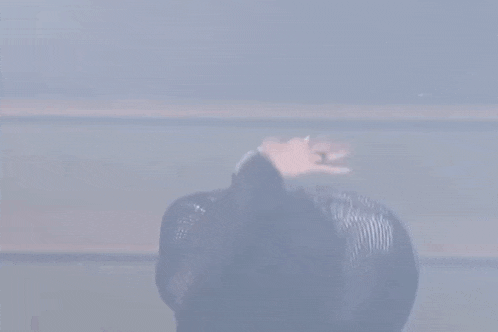 a man in a black leather jacket is dancing on a stage