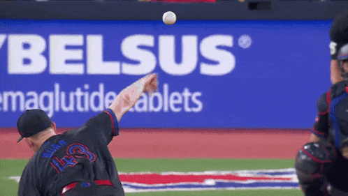 a baseball player throwing a ball in front of a sign that says belsus