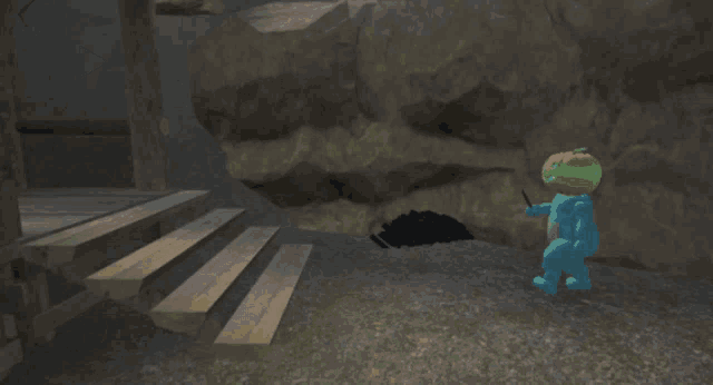 a blue teddy bear with a pumpkin head stands in front of a cave