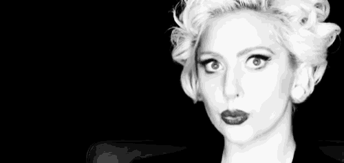 a black and white photo of a woman 's face with blonde hair and red lips .