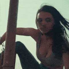 a woman with a large breast is sitting on the floor