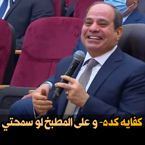 a man in a suit is holding a microphone and smiling