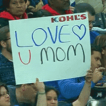 a group of people holding up a sign that says " love u mom "