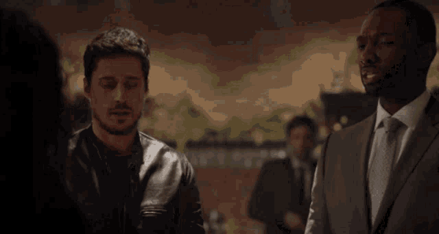 a man in a suit is talking to another man