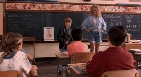 a woman is standing in front of a blackboard that says reproduction on it