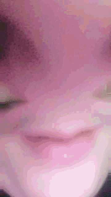 a close up of a child 's face with a pink background