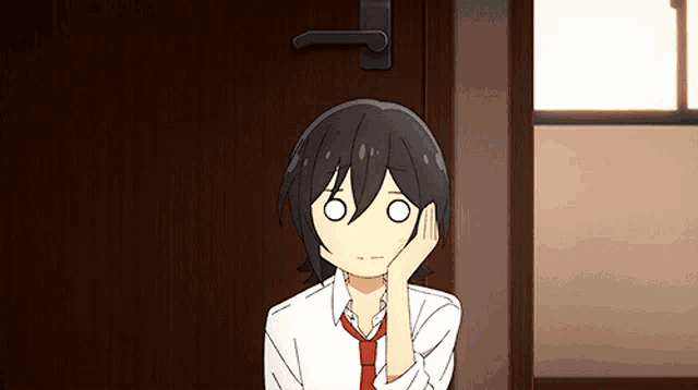 a cartoon character with black hair and a red tie is sitting in front of a door .