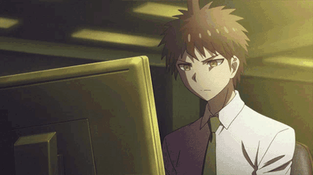 a man in a suit and tie is sitting in front of a computer