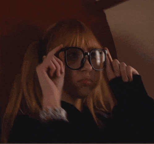 a blurry picture of a woman with blonde hair covering her face with her hands