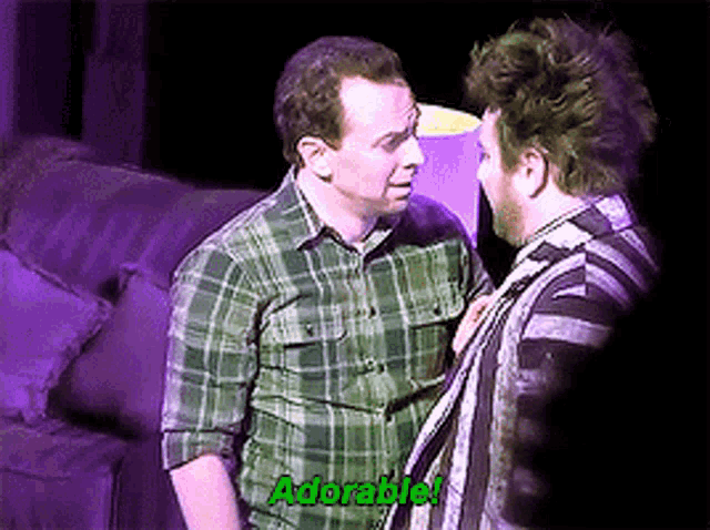 a man in a plaid shirt is talking to another man in a striped shirt ..