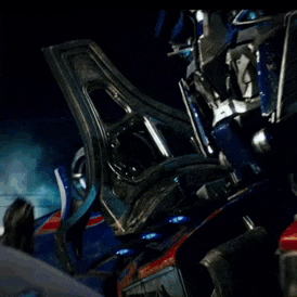 a man is looking at a blue robot with a helmet on .