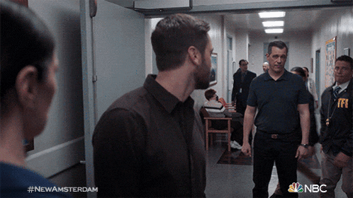 a group of people are standing in a hallway with the hashtag #newamsterdam