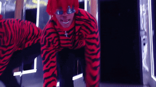 a man in a red and black zebra print costume is crawling