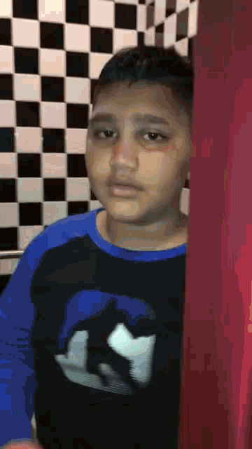 a young boy wearing a blue and black shirt with a picture of a man on it