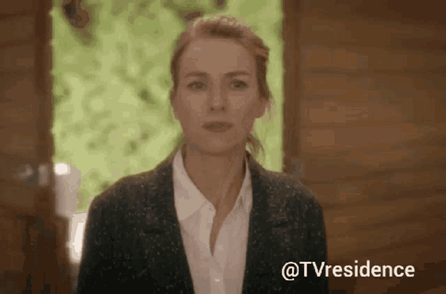 a woman is standing in front of a wooden door and the words @tvresidence are above her
