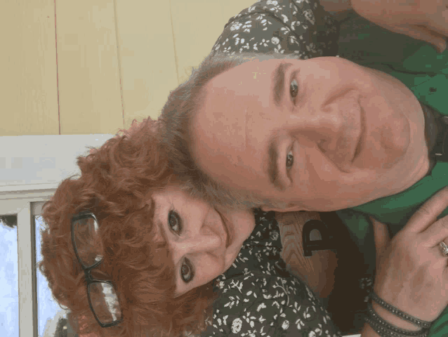 a man and a woman are posing for a picture and the man is wearing a green shirt with the letter p on the back